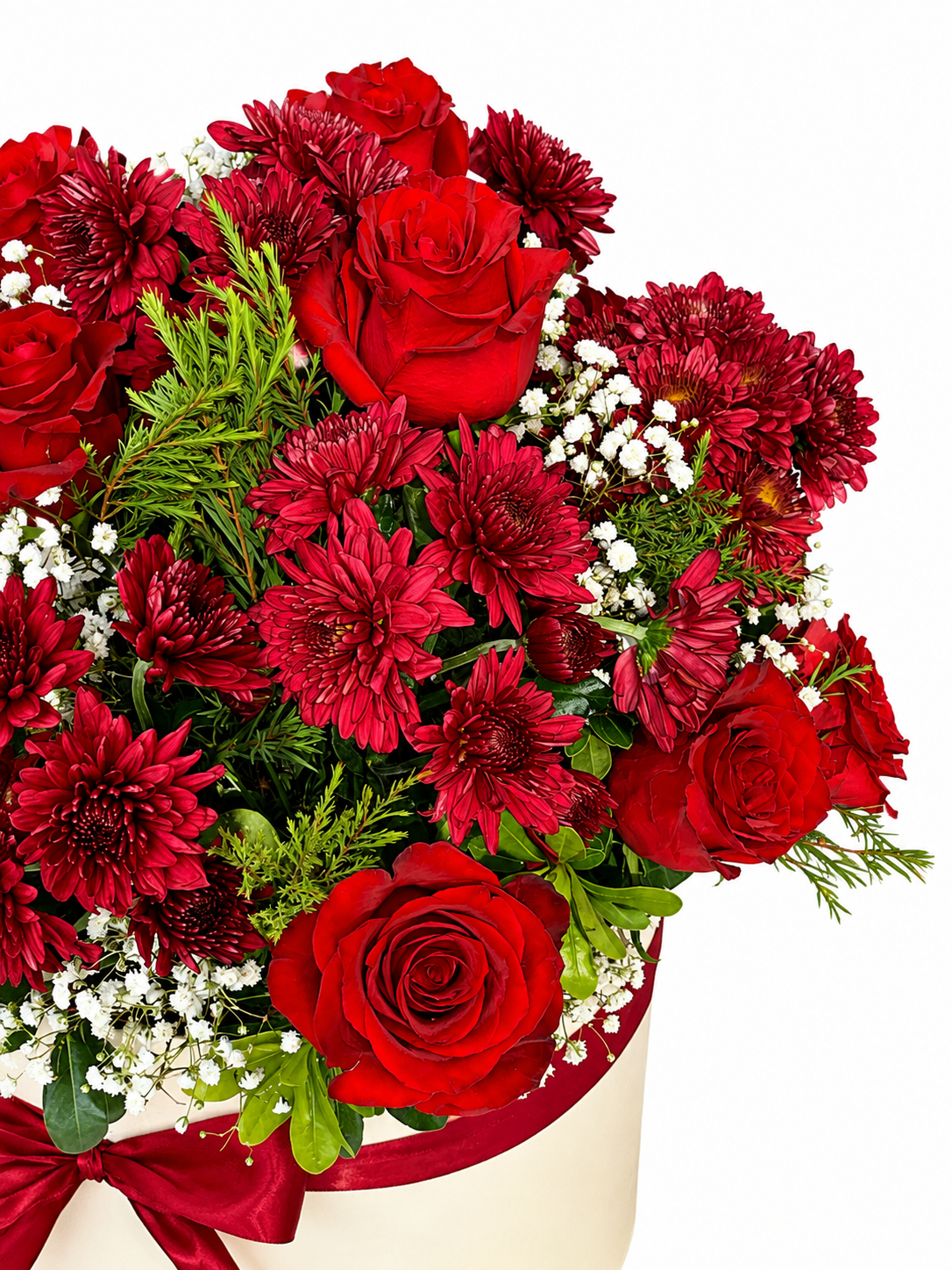 A vibrant flower bouquet featuring red roses, dark red chrysanthemums, green foliage, and small white baby&