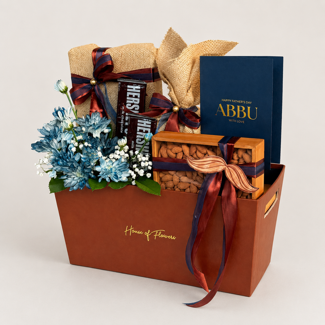 The Legacy Bundle gift box with chocolate, nuts, blue flowers, and an &