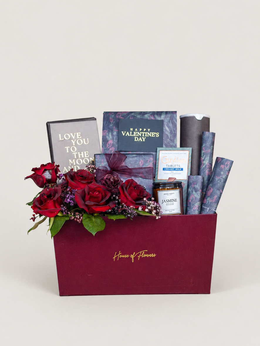 Luxury Valentine’s Day gift box with red roses, blue gift items, and greeting card.
