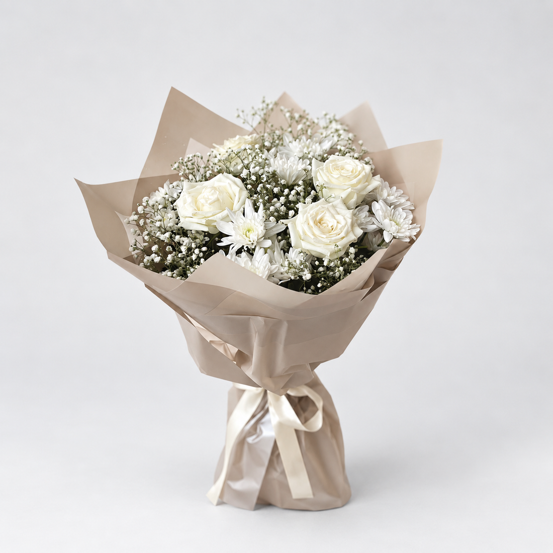A bouquet of white roses, white chrysanthemums, and baby&