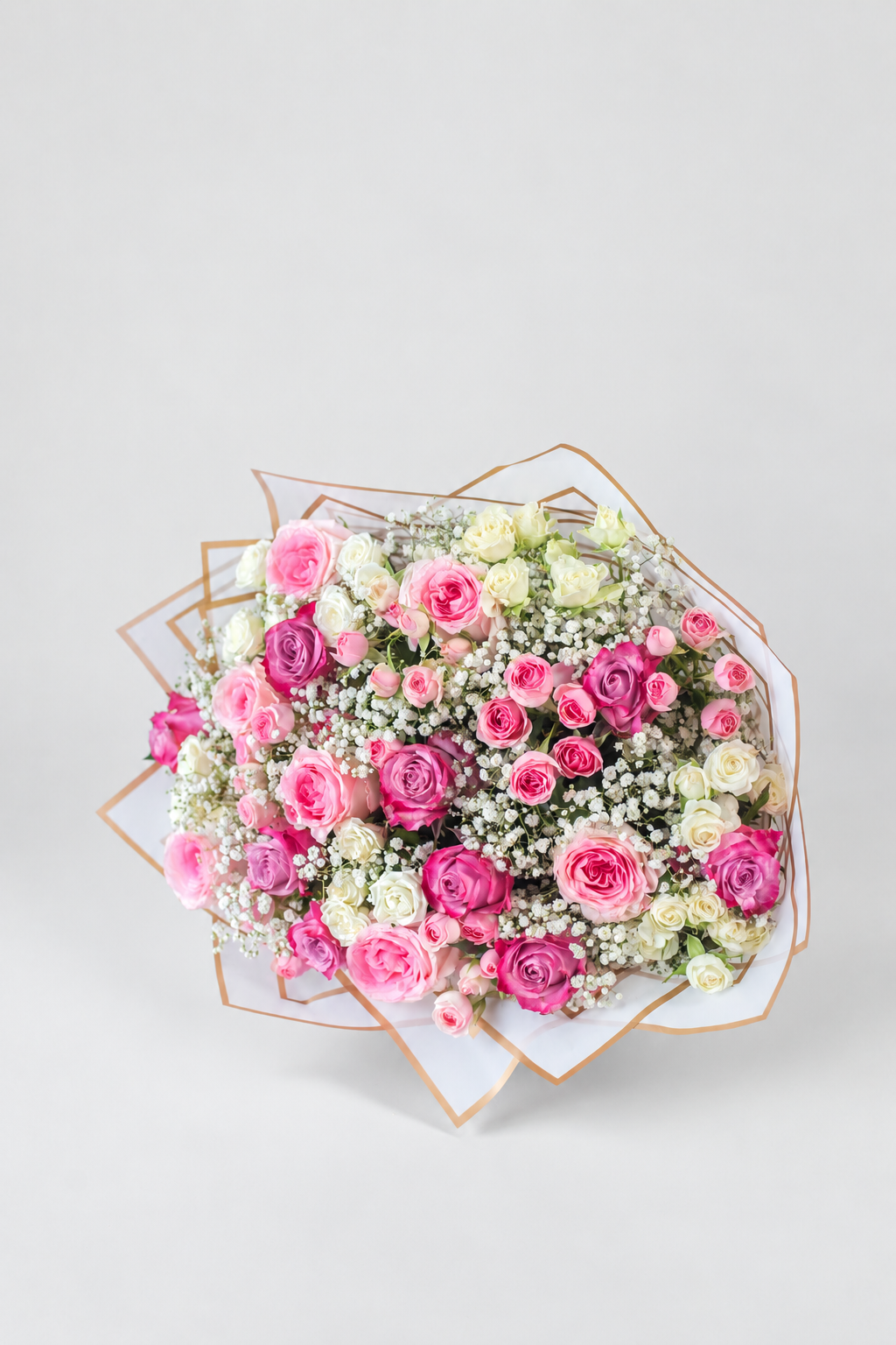 A round floral bouquet featuring pink and white roses, baby&