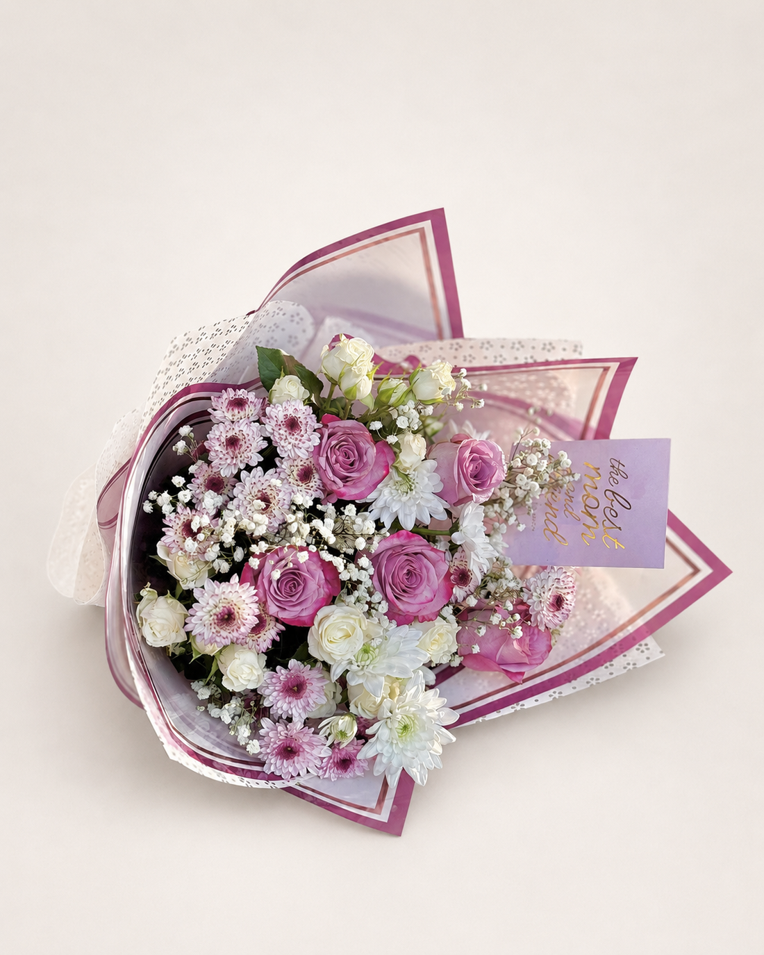 Eternal Maternal bouquet with pink and white roses and white chrysanthemums, wrapped in patterned pink paper with a "Best Mom" card