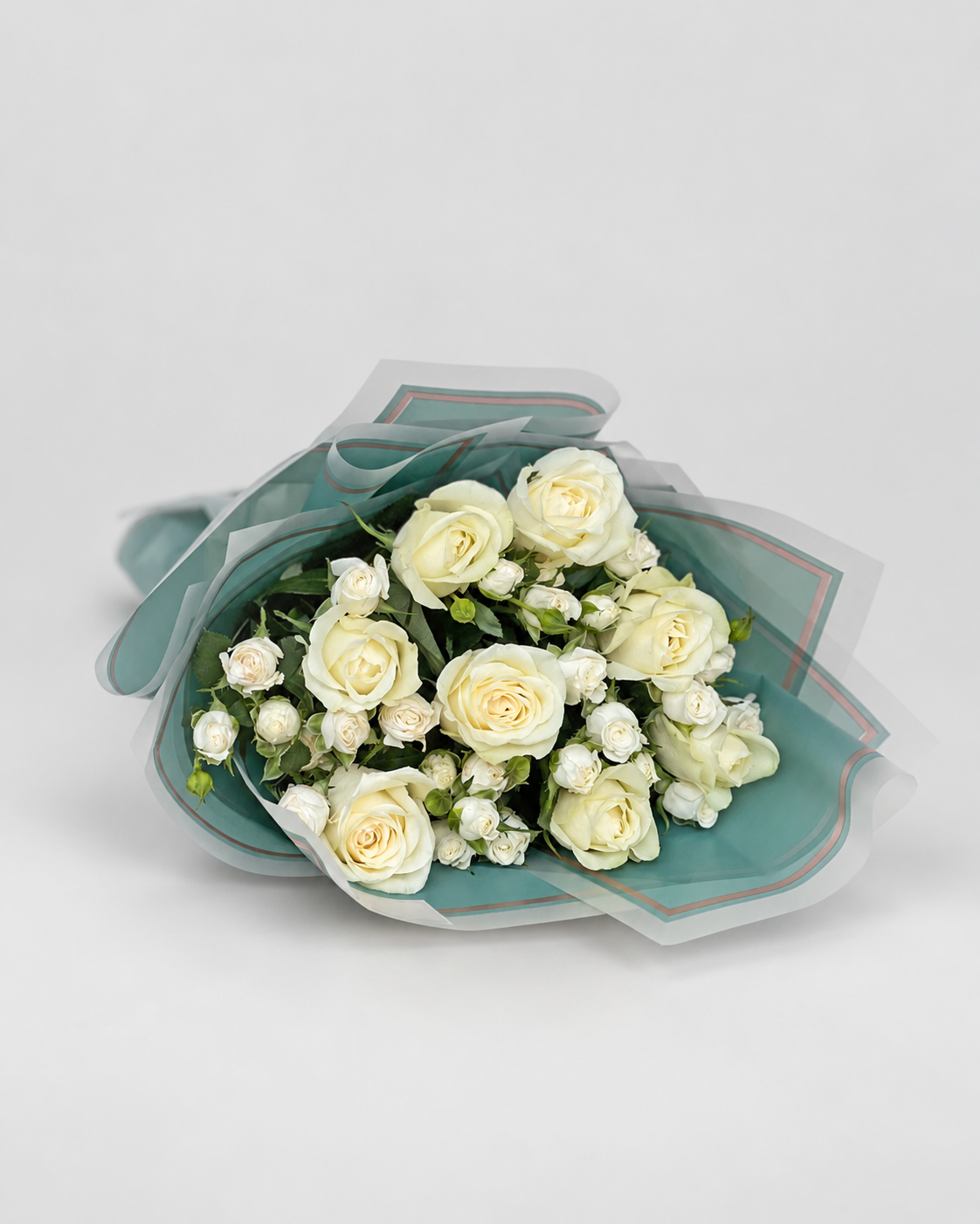 Bouquet of white flowers in a teal wrap on a gray surface with &
