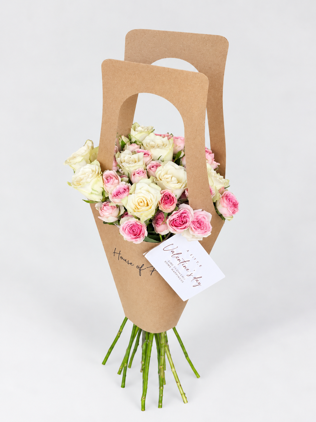 Little Love bouquet of pink and white roses in a kraft paper bag with a card