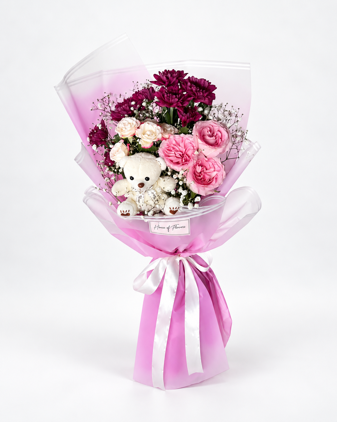 Bouquet with a mixture of different flowers and a teddy.