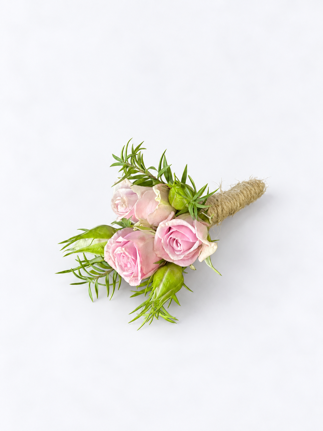 Pink spray rose boutonniere with greenery and a twine-wrapped stem