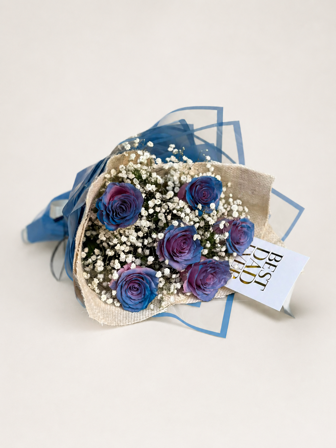 The Protector blue and purple rose bouquet with baby’s breath and a greeting car