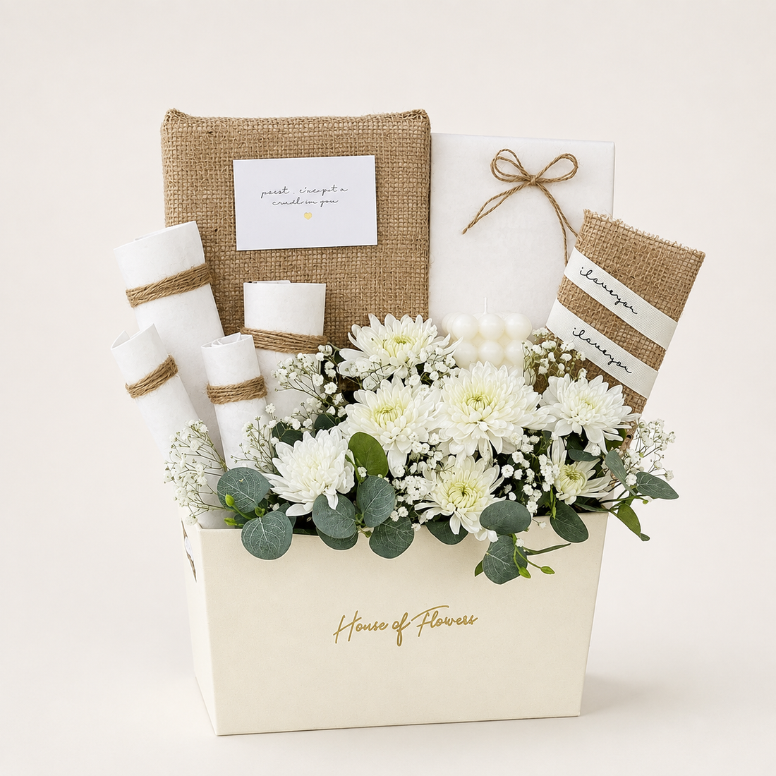 A floral gift basket arrangement in a cream-colored box with the words &