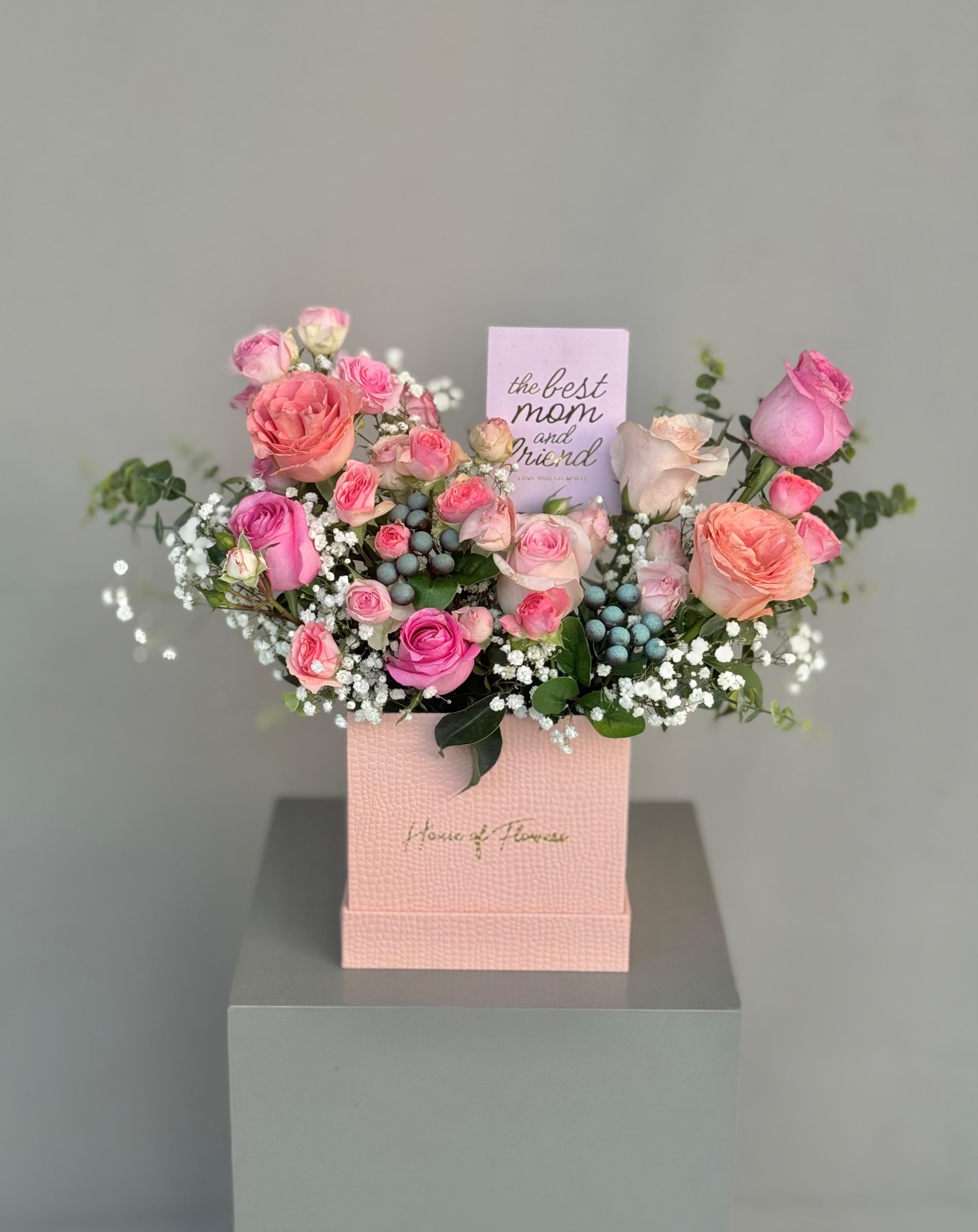 Peach Symphony arrangement with peach, pink and coral roses and gypsophila in a pink box, with a "Best Mom Ever" card