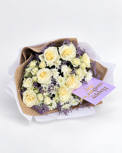 Whispers of Love bouquet of cream roses and purple statice in burlap wrap