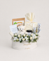 Creamsicle Charm white round box with white roses and chrysanthemums, a white teddy bear, gourmet snacks and a wrapped cream gift box