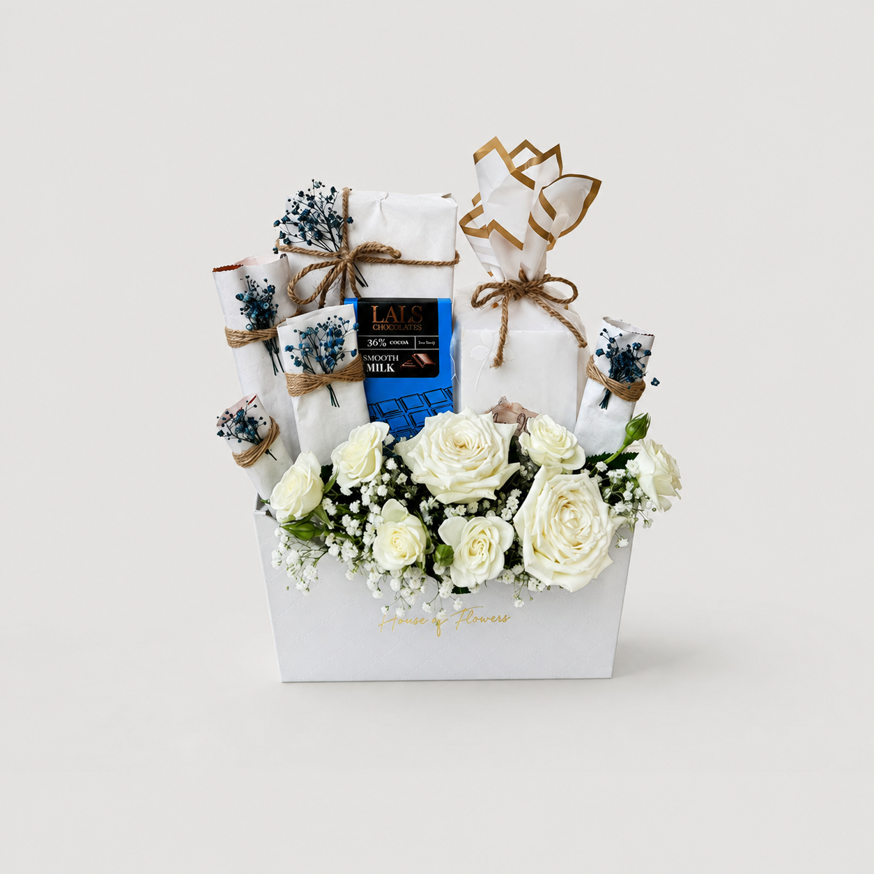 A curated gift basket arrangement in a white box with white roses, baby&