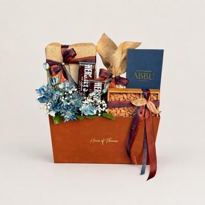 The Legacy Bundle gift box with chocolate, nuts, blue flowers, and an &