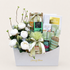 An elegant gift basket from House of Flavor, filled with an assortment of gourmet treats, soaps, and a floral arrangement of white roses and greenery, presented on a light beige background.