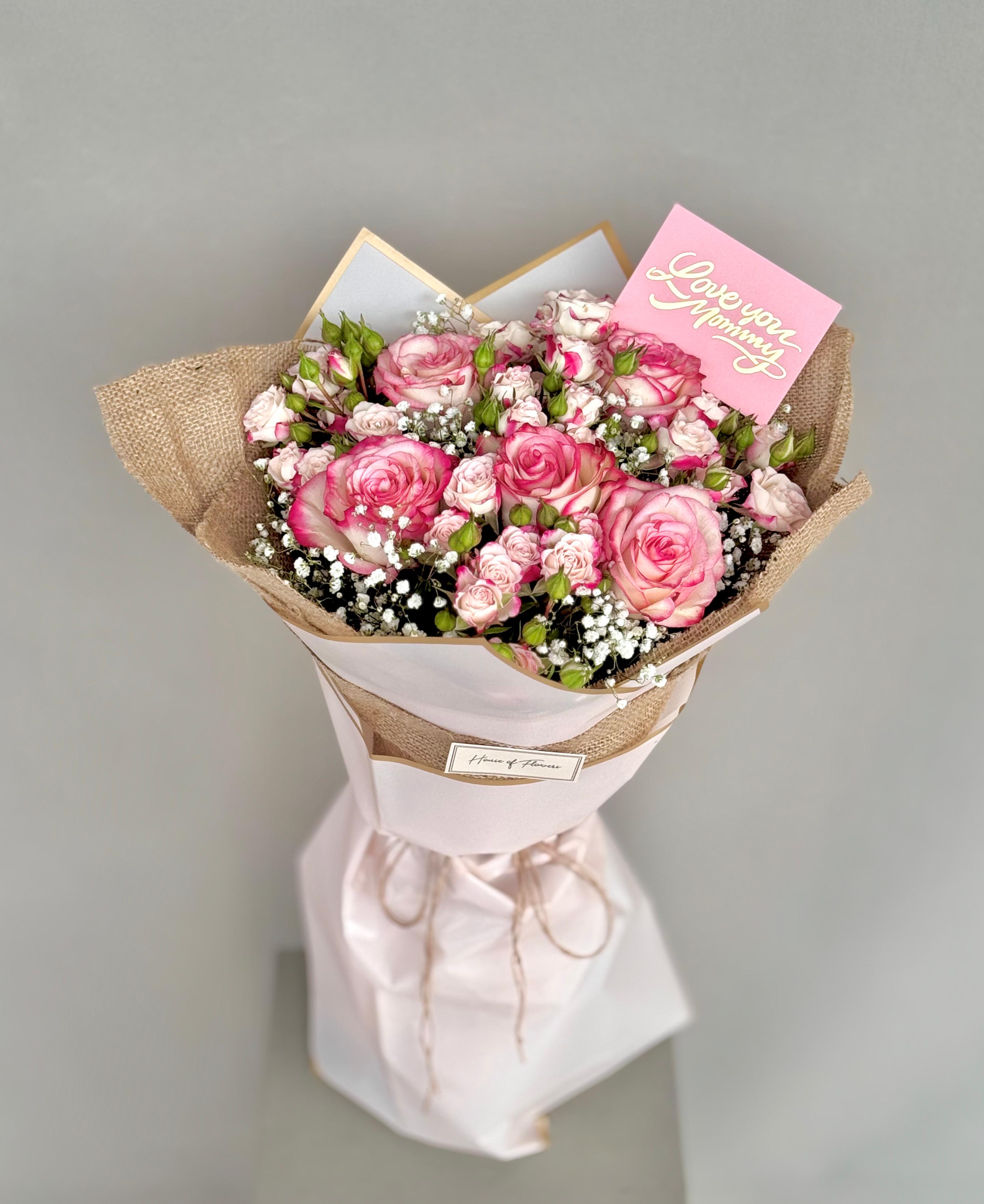 Bouquet of pink roses with a card on a gray background