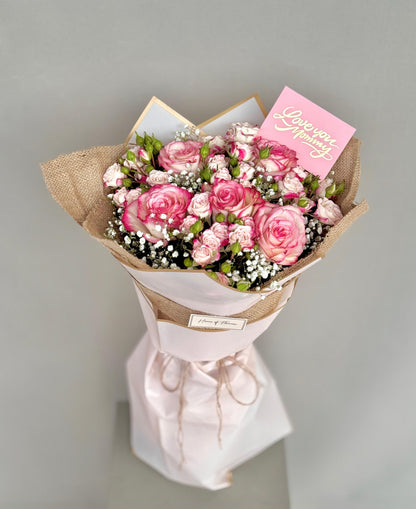 Bouquet of pink roses with a card on a gray background