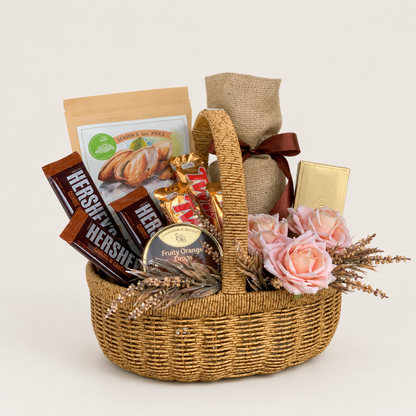 A wicker gift basket filled with assorted treats, including Hershey&