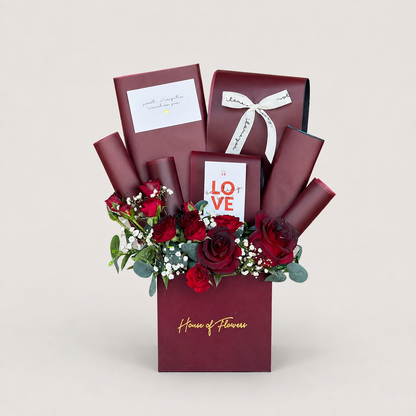 A floral gift box arrangement from House of Flowers, featuring deep red roses, green foliage, white baby&