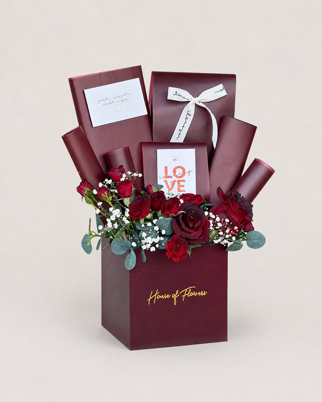 A premium gift box arrangement from House of Flowers featuring deep burgundy roses, red carnations, baby&