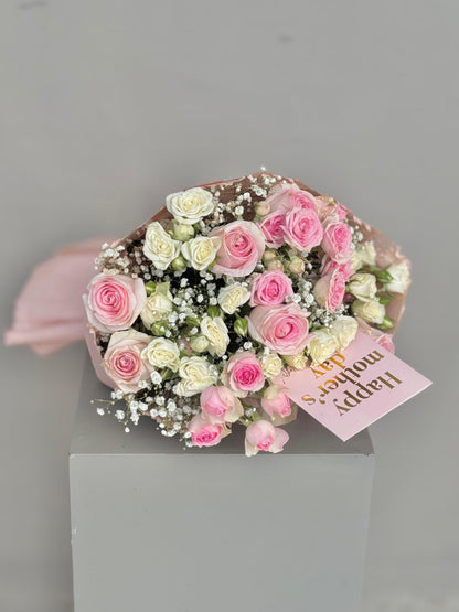Bouquet of pink and white roses with a card on a gray background