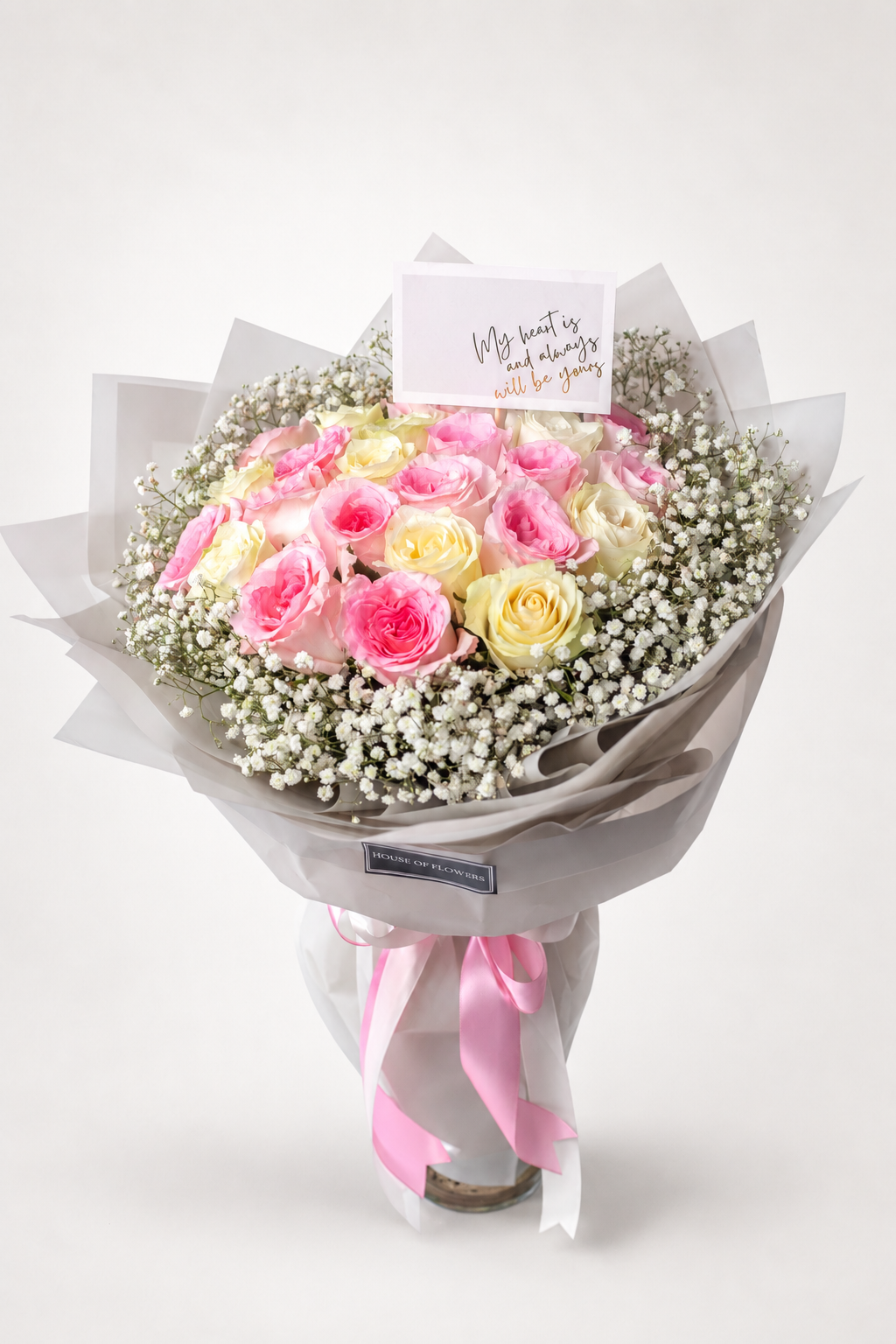 A bouquet of pink and pale yellow roses mixed with white baby&