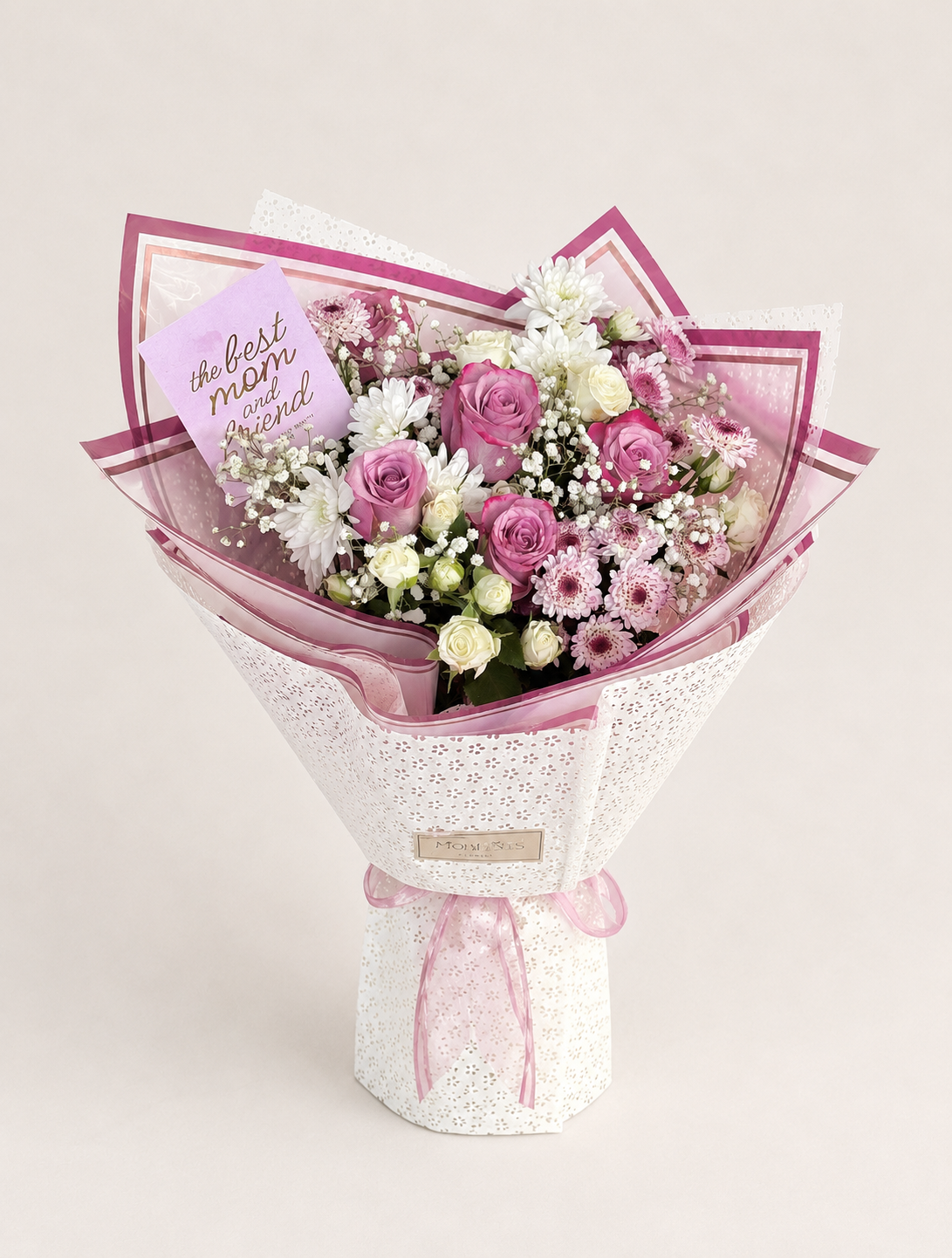 Eternal Maternal bouquet with pink and white roses and white chrysanthemums, wrapped in patterned pink paper with a "Best Mom" card