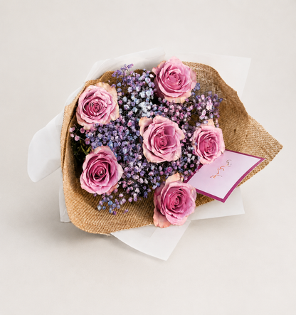 A bouquet of pink roses and purple baby&