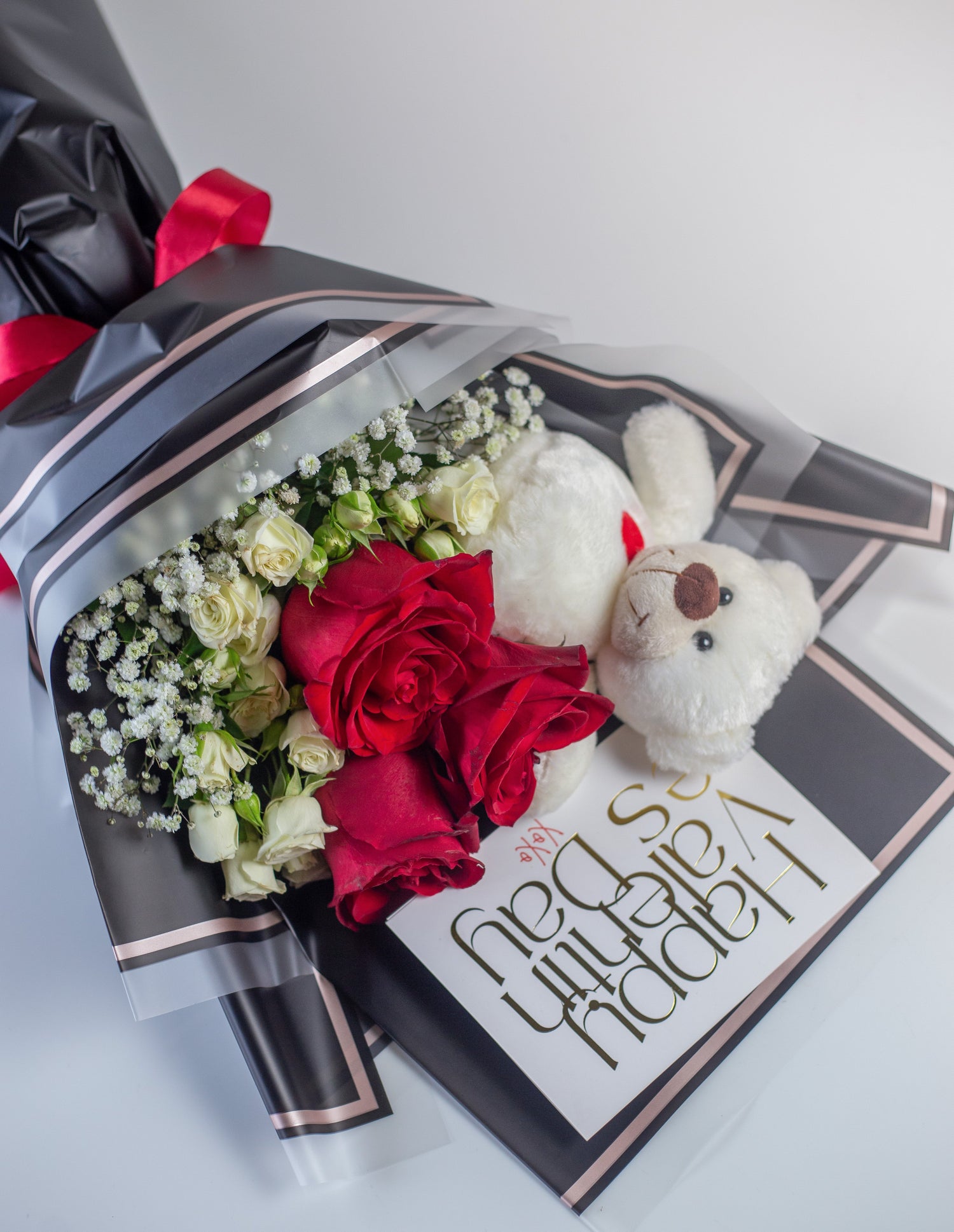a bouquet with red roses, white spray roses , gypso and a teddy. Wrapped exquisitely in a premium sheet.