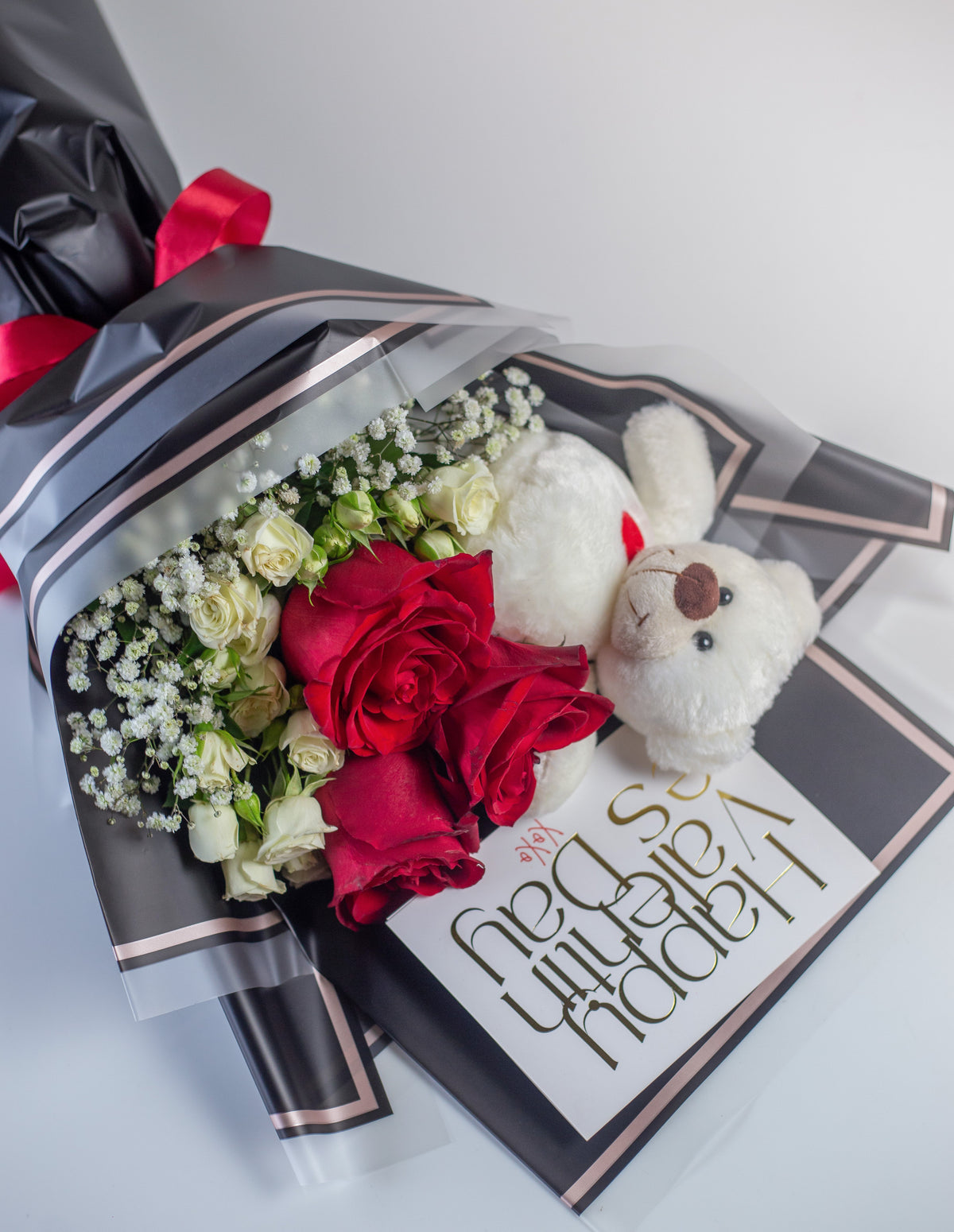 a bouquet with red roses, white spray roses , gypso and a teddy. Wrapped exquisitely in a premium sheet.