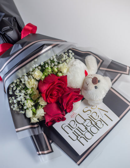 a bouquet with red roses, white spray roses , gypso and a teddy. Wrapped exquisitely in a premium sheet.