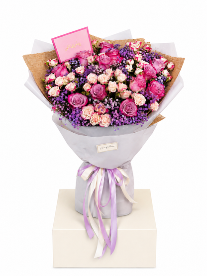 A vibrant flower bouquet featuring pink and purple roses, pink baby&