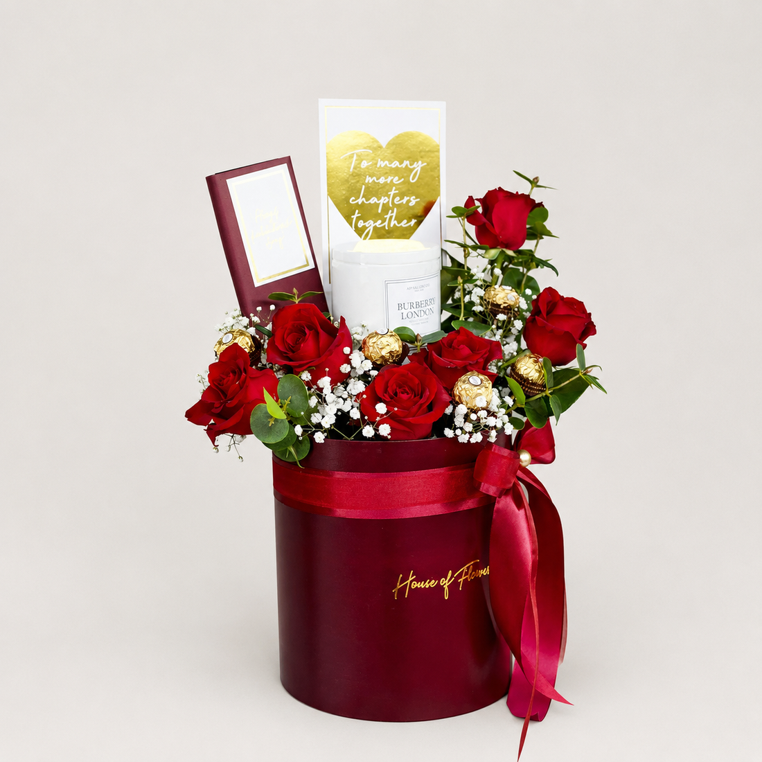 A red cylindrical gift box filled with red roses, white baby&