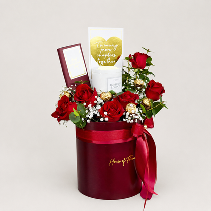 A red cylindrical gift box filled with red roses, white baby&