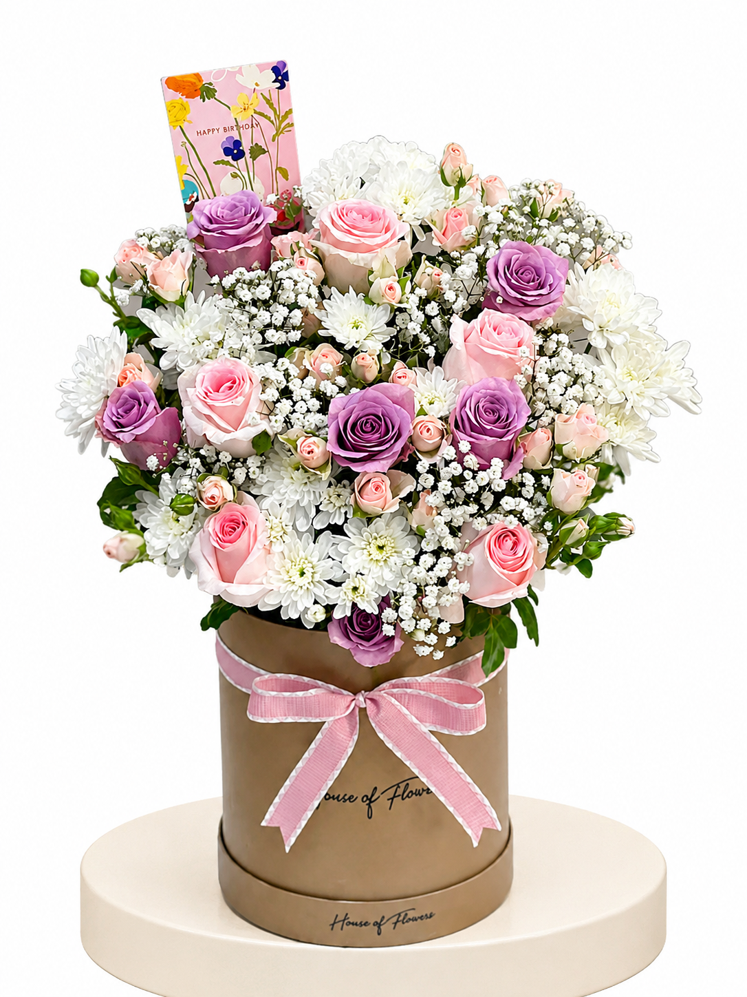 A floral gift arrangement featuring pink and purple roses, white daisies, and baby&