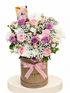 A floral gift arrangement featuring pink and purple roses, white daisies, and baby&