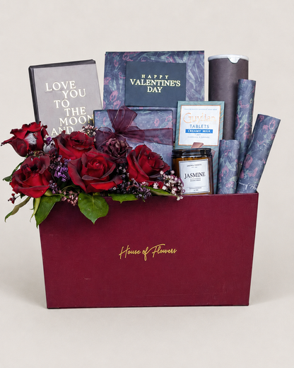 Luxury Valentine’s Day gift box with red roses, blue gift items, and greeting card.