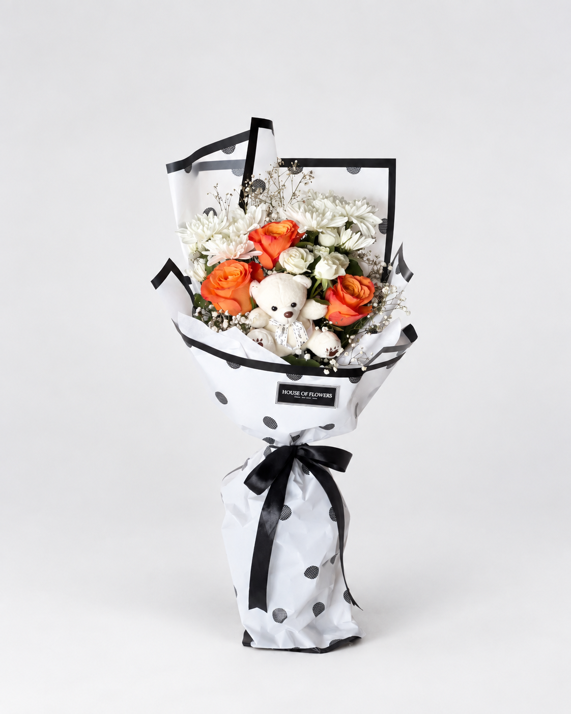 Bouquet with a mixture of different flowers and a teddy.