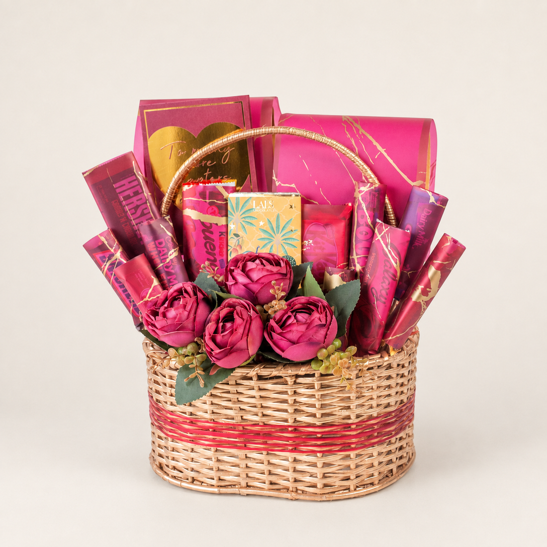 Pink Divia gift box filled with assorted chocolates, snacks, and artificial flowers