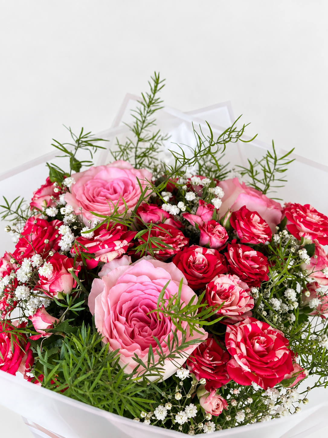 Bouquet of pink and green flowers in clear plastic wrap