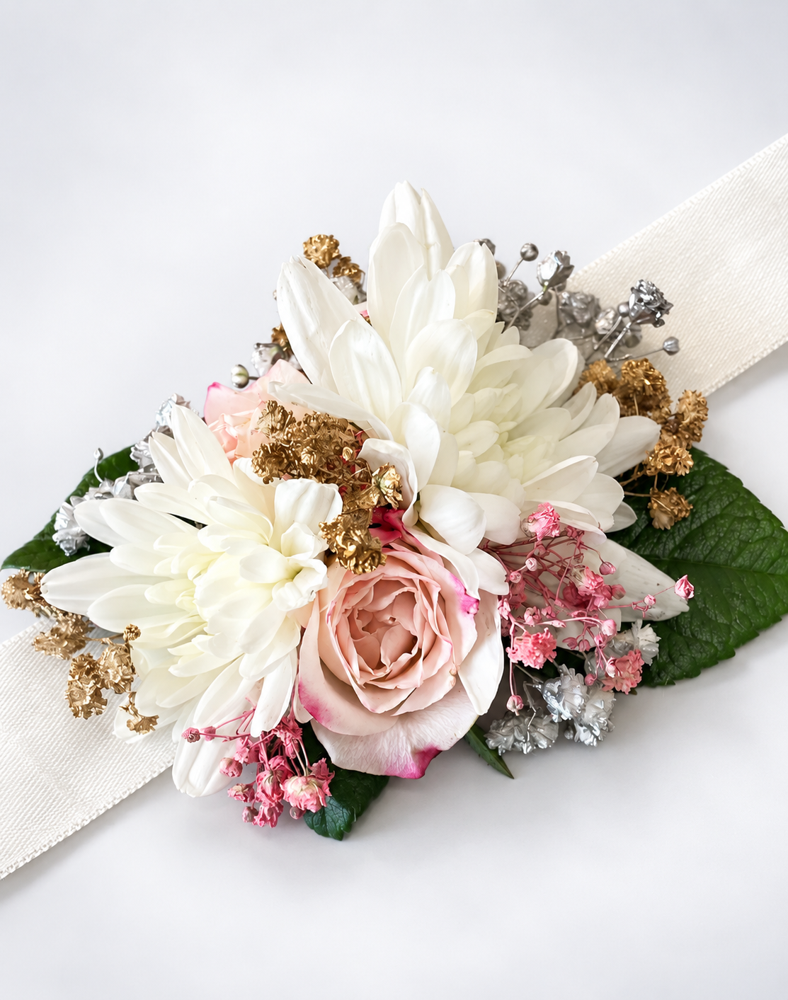 Wrist corsage with white chrysanthemums, a blush rose and gold accents on a cream ribbon