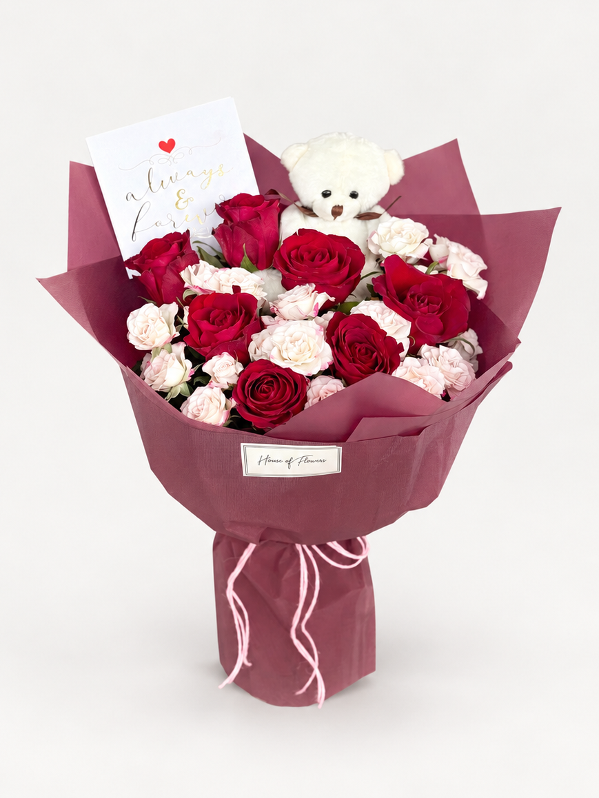 Rosette Etude bouquet of red roses and pink spray roses with a white teddy bear, wrapped in maroon paper with a heart card