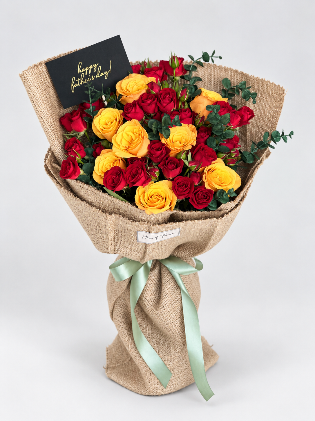 Crimson and Gold Serenade bouquet of red and orange roses with a greeting card