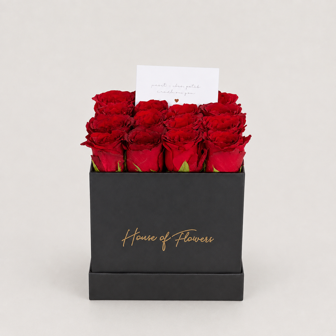 A gift box of 12 red roses in a square kraft paper box with &