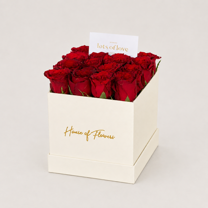 A gift box of 12 red roses in a square kraft paper box with &