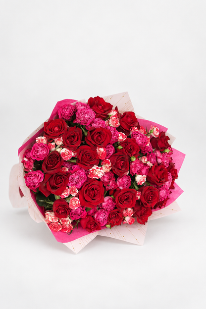 Scarlet Muse bouquet of red and pink roses with spray roses, wrapped in pink and white paper