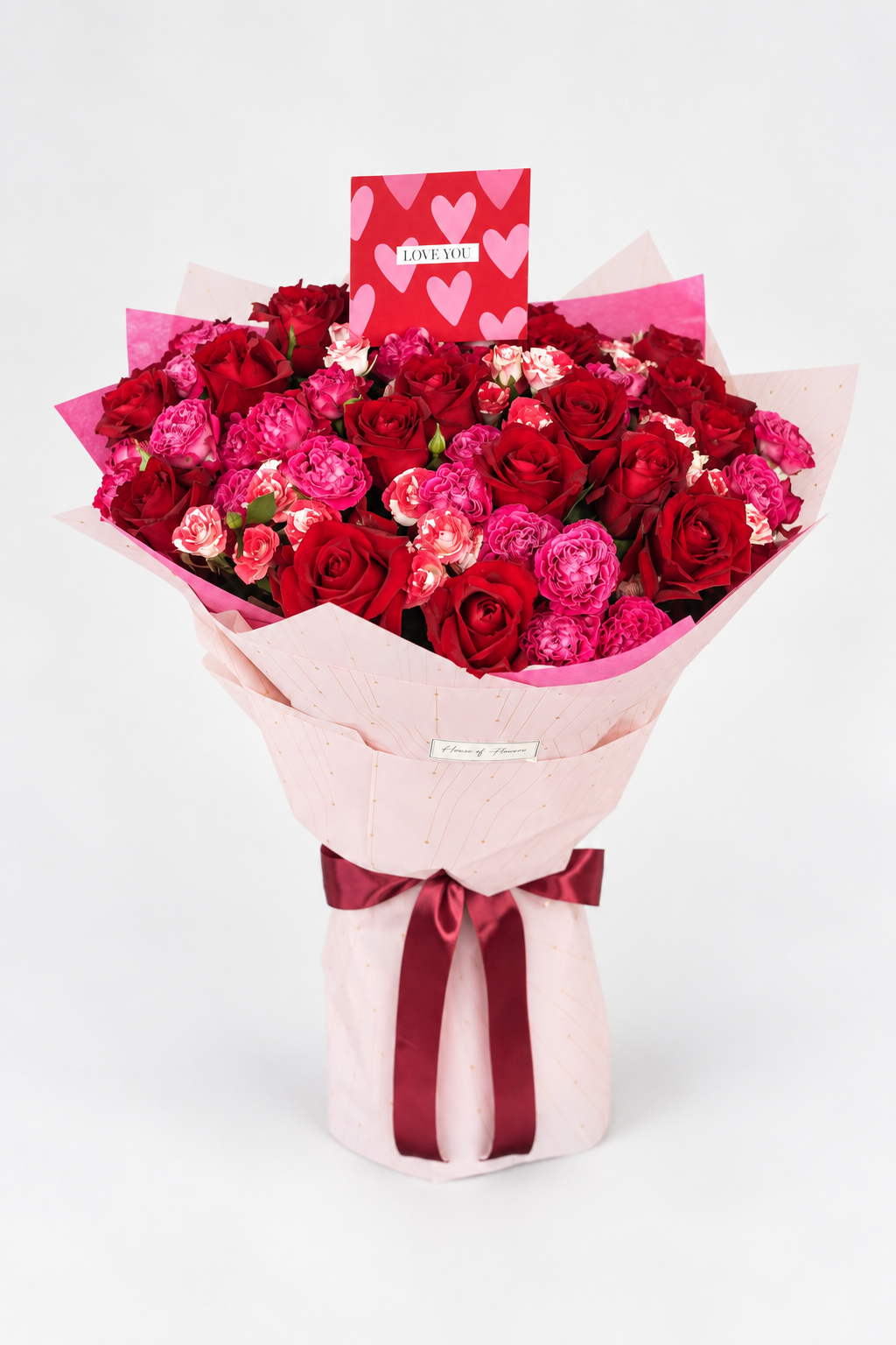 Scarlet Muse bouquet of red and pink roses with spray roses, wrapped in pink and white paper