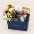 Sunlight & Strength gift box with sunflowers, roses, gypso, almonds, cookies, chocolate, a candle, wafers, and greeting card.