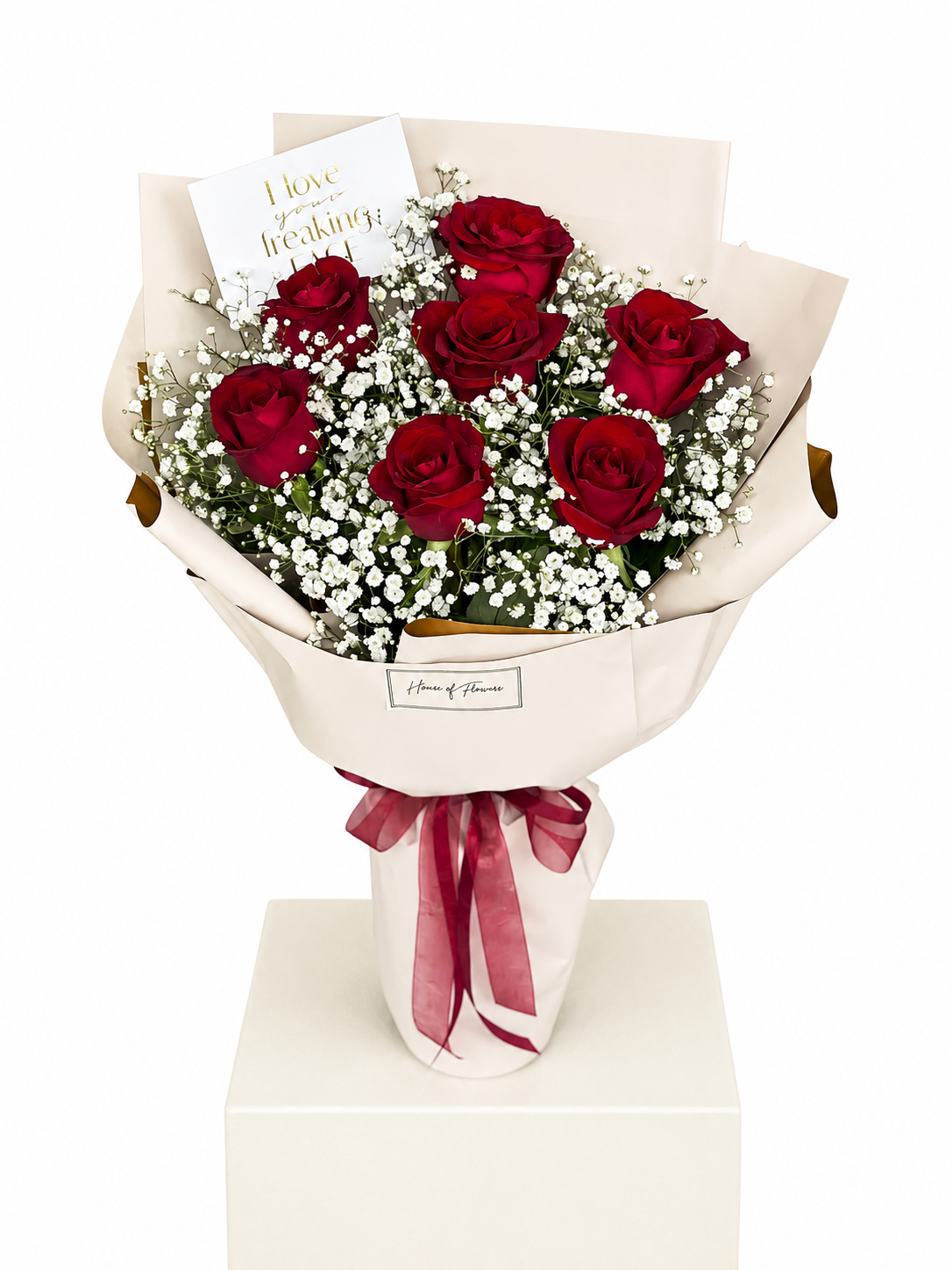 A bouquet of seven red roses and white baby&