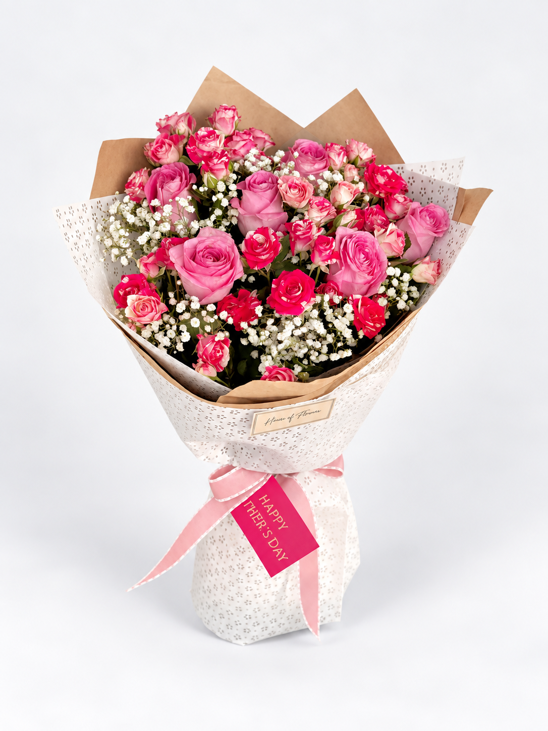 Timeless Tribute bouquet with pink and hot pink roses and gypsophila, wrapped in kraft and white paper with a pink ribbon and card