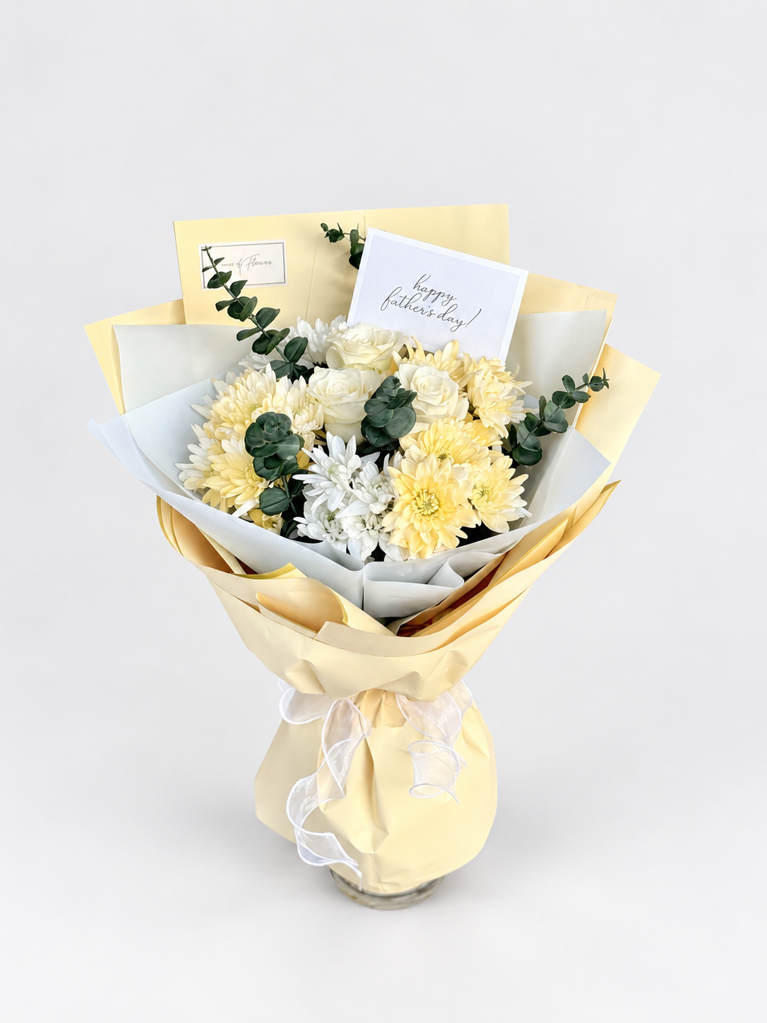 Warmth of You bouquet with cream and white chrysanthemums and eucalyptus, wrapped in soft yellow paper with greeting cards